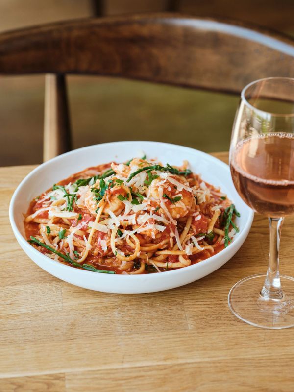 Bowl of seafood spaghetti and glass of rose wine