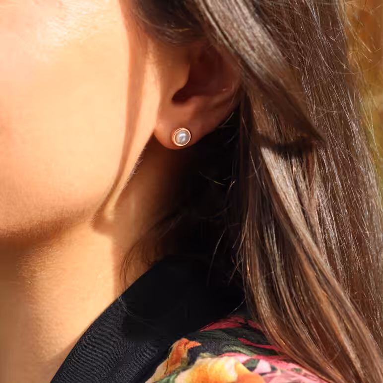 Model wearing Jersey Pearl Alice Rose Gold Small Stud Earrings. White Freshwater Button Pearls set in Sterling Silver with Rose Gold Plating