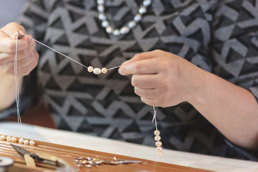 woman stringing pearls at jersey pearl