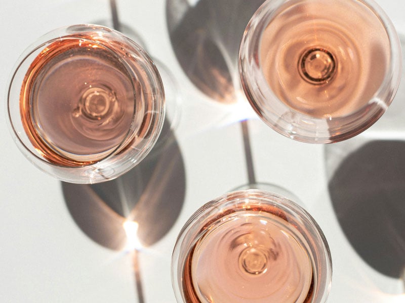 three glasses of rose wine shot from above with shadows
