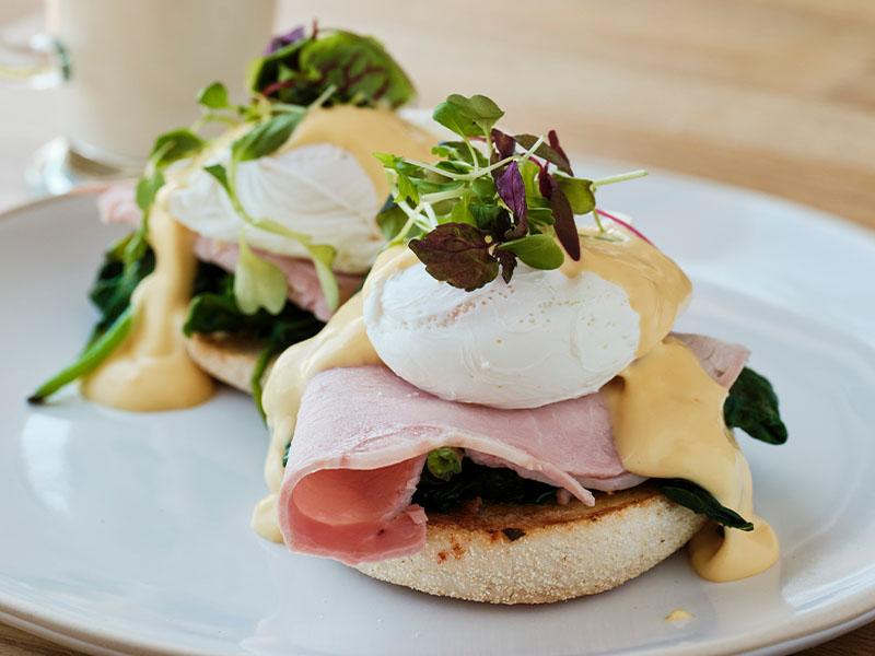 close up shot of eggs Benedict on a white plate