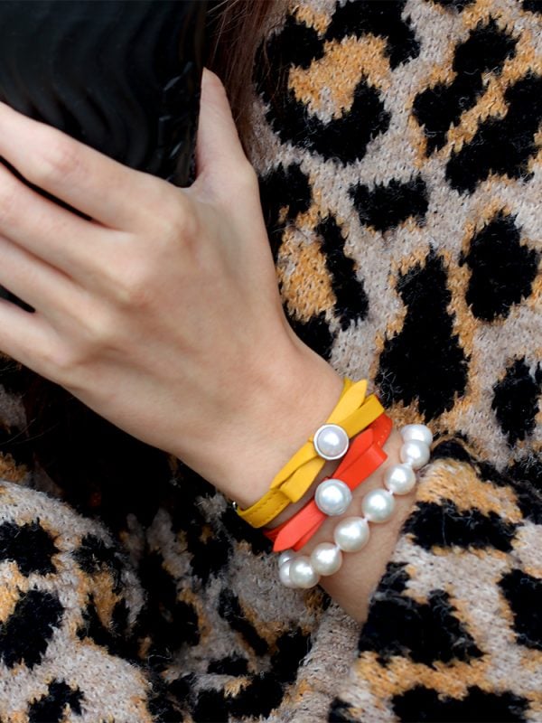 Model wearing Edison Pearl Zara bracelet with yellow and coral coloured Joli bracelets