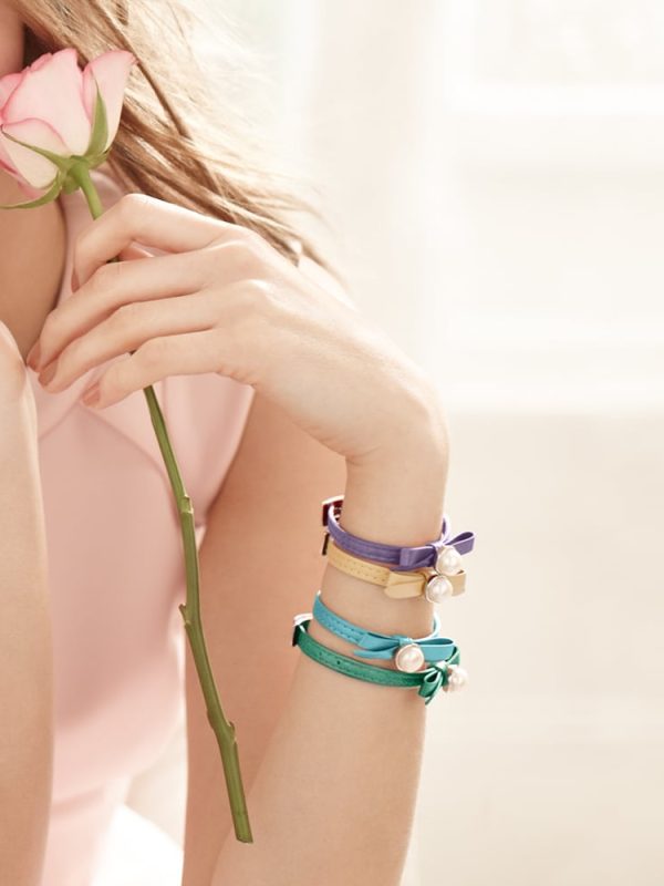 Model holding pink Rose wearing Joli Bracelets