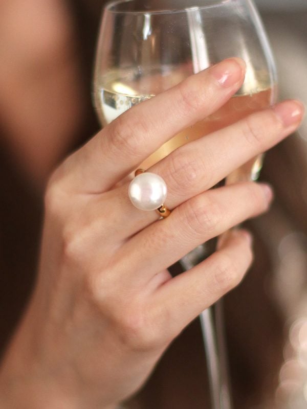 model holding a wine glass wearing a baroque pearl ring