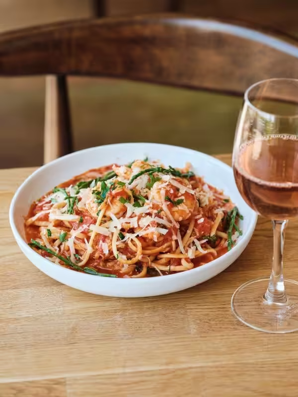 Bowl of seafood spaghetti and glass of rose wine