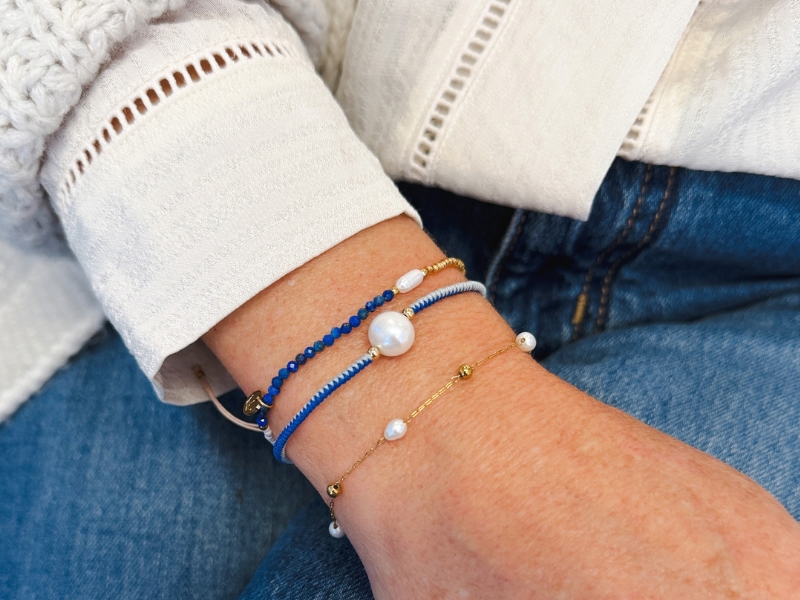 stack of three pearl bracelets on womans arm including jersey hospice charity tassel bracelet
