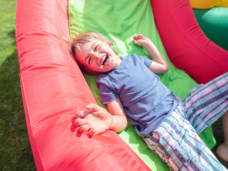 boy sliding down the bouncy castle