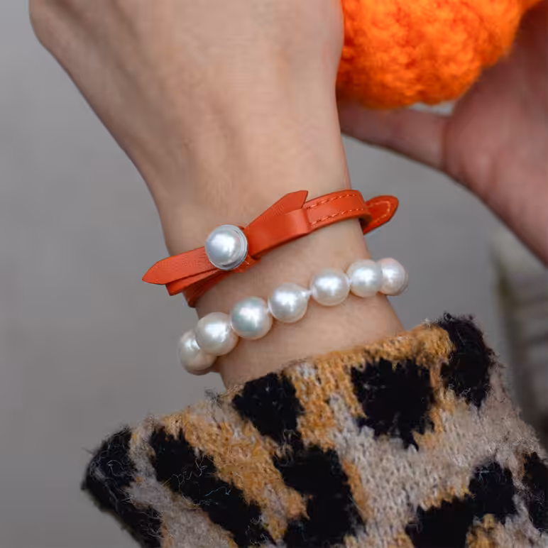 Model wearing Coral Joli bracelet with Zara Edison White Pearl bracelet