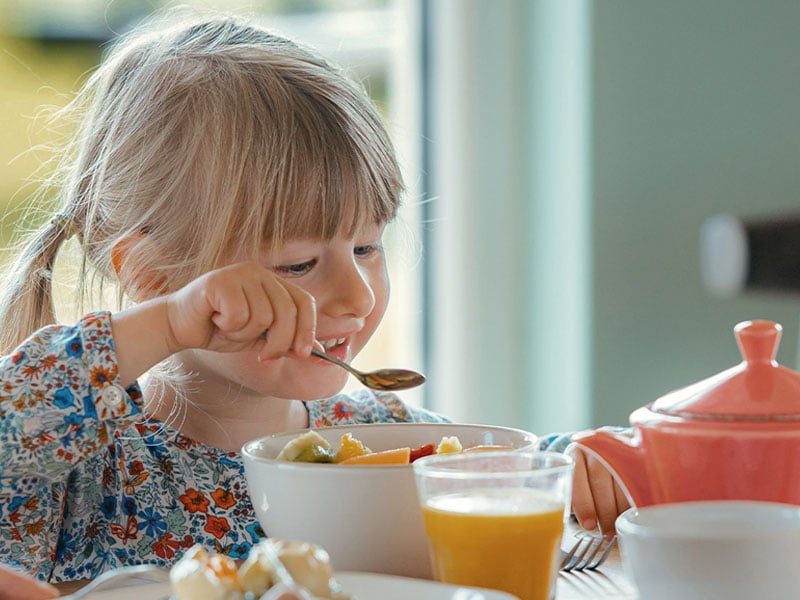 Little girl eating her breakfast in the jersey pearl cafe